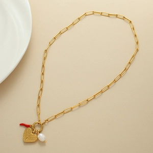 Dettaglio collana a graffetta in oro 18K con ciondoli a cuore, peperoncino e perla