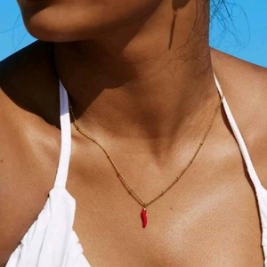 Minimalistische goldene Kugelkette mit rotem Chili-Anhänger getragen von einem Model