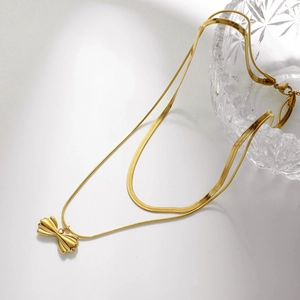 Double-layered gold snake chain necklace featuring a 3D bow pendant on white background