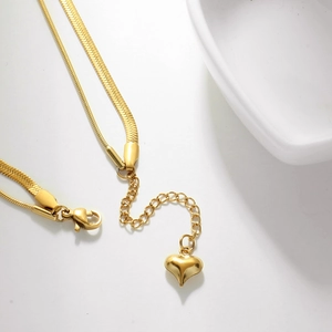 Detail of double-layer gold snake chain with lobster clasp and heart pendant