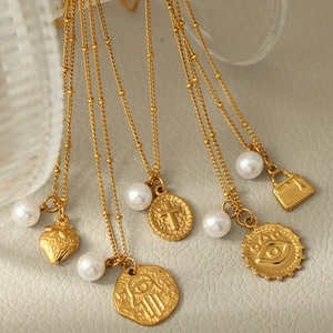 Série de colliers dorés à pendentifs perles et cœurs sur fond de cuir élégant
