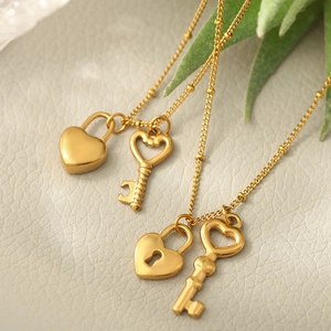 Détail du collier avec pendentif cœur et clé en acier inoxydable doré sur fond cuir