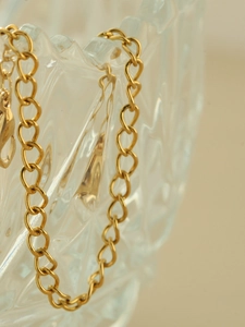 Detailed macro view of a stylish gold metal link chain with polished oval links