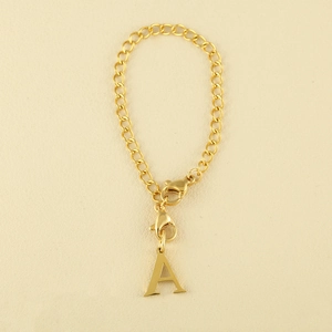 Detailed view of a polished gold letter A pendant on a chunky curb chain with lobster clasps
