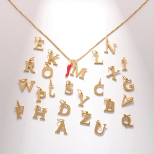 Macro shot of 18k gold plated necklace with red pepper and custom initial pendants