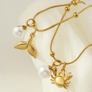 Gold ocean necklace set with starfish crab pendants and white pearls on snake chain
