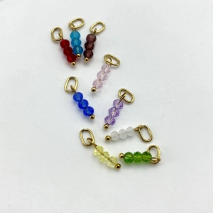 Close-up of faceted crystal bead charms in nine colors for DIY jewelry making