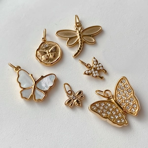 Detalle de dijes dorados de insectos con motivos de mariposas y libélulas para joyería DIY