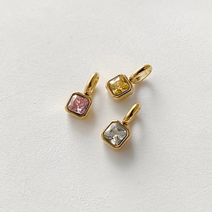 Tre pendenti quadrati placcati oro con pietre di zircone colorate taglio princess su bianco