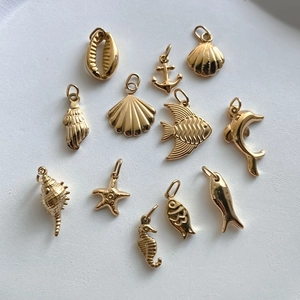 11-piece set of gold stainless steel ocean pendants featuring starfish, seahorse, and dolphin