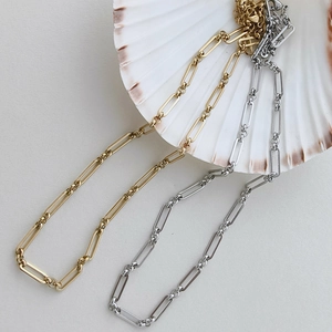 Détail du collier chaîne trombone en or 18K et argent avec fermoir mousqueton sur coquillage