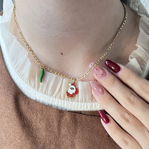Details einer goldenen Figaro-Halskette mit Emaille-Weihnachtsmann-Anhängern