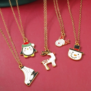 Detalle de 5 collares navideños dorados de esmalte con colgantes festivos en fondo rojo