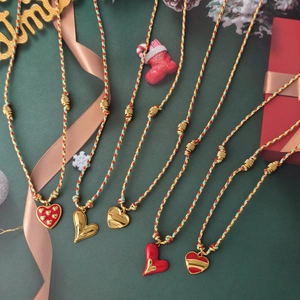 Five heart pendant necklaces with colorful woven cords and festive holiday decorations
