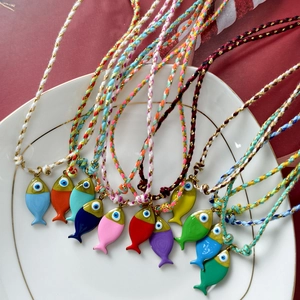Collares bohemios de cuerda tejida de colores con colgantes de peces en un plato