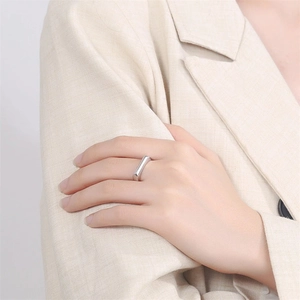 Polished silver rectangular signet ring worn with a beige suit for a minimalist look