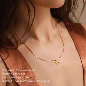Detail of a 10mm round letter pendant on 38+5cm chain in 14K gold stainless steel