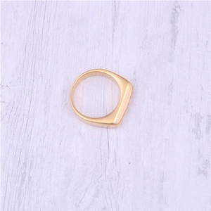 Detailed view of polished 18K gold plated stainless steel signet ring on purple wood