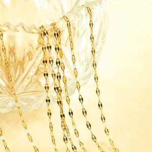 Elegante gouden hartketting met bladschakelketting gedrapeerd over een glazen kom