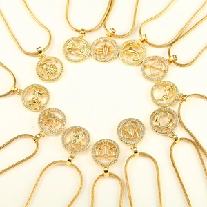 Golden zodiac pendant necklaces set with zircon crystals on flat lay background