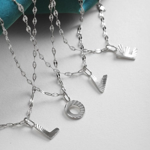 Silver letter LOVE pendant necklace set with radiant texture and faceted fine chain