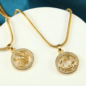 Close-up of Scorpio and Pisces gold plated zodiac pendants with white micro-stones on snake chain