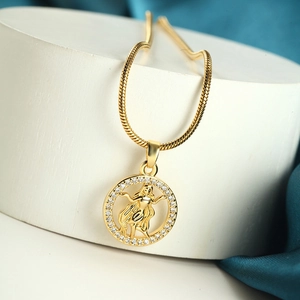 Detail of gold zodiac pendant with snake chain and crystal border on blue silk