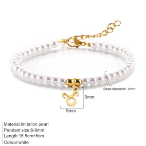 Pulsera de perlas blancas con colgante de Tauro dorado y cierre ajustable en fondo blanco