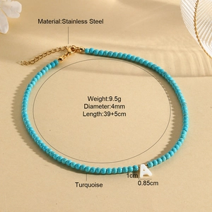 Detailed view of turquoise bead necklace with shell initial A pendant and golden clasp