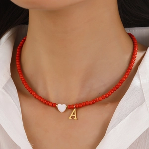 Red beaded necklace with white heart and golden letter A charm for women