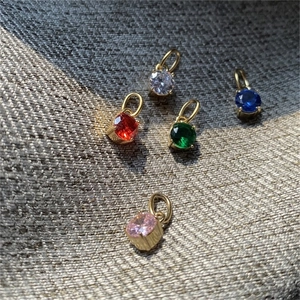 Vue macro de 5 pendentifs en zircon coloré pour bijoux DIY avec cadres en métal doré