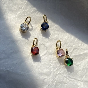 Vue macro de cinq breloques en zircon coloré avec placage en or et sertis à quatre griffes