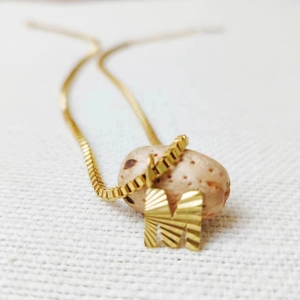 Minimalist stainless steel necklace featuring a golden textured letter M pendant on a box chain