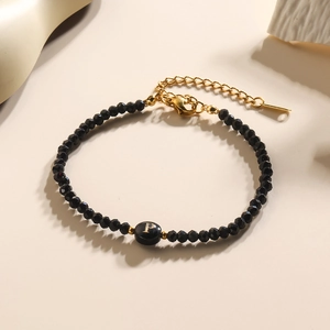Zwarte gefacetteerde kralenarmband met gouden letter P bedeltje en karabijnsluiting