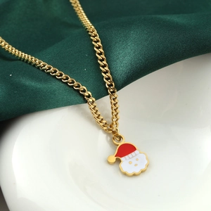 Weihnachts-Nikolaus-Halskette aus goldenem Edelstahl auf grünem Seidenhintergrund