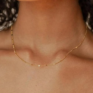 Nahaufnahme einer minimalistischen goldenen Edelstahl-Perlenkette an einem Modell