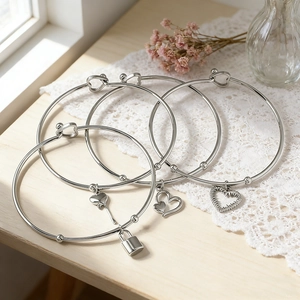 Set van vier zilveren roestvrijstalen armbanden met hartjes en slotje op wit kantwerk