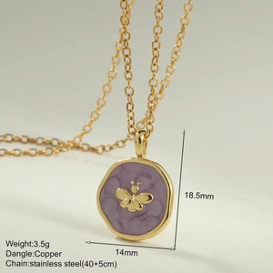 Macro shot of gold stainless steel necklace featuring a purple enamel bee pendant detail