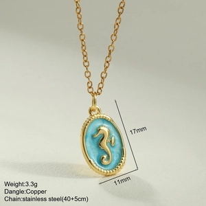Macro shot of gold-plated seahorse pendant with turquoise enamel and steel chain