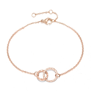 Détail d'un bracelet en or rose avec anneaux entrelacés à texture martelée et fermoir mousqueton