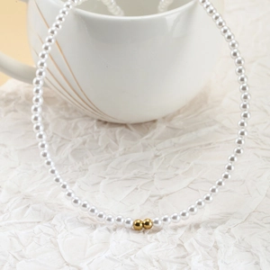 Elegant pearl necklace with gold bead accents shown on minimalist white background