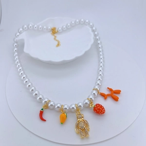 Faux pearl necklace with colorful charms like chili, teddy bear, and strawberry