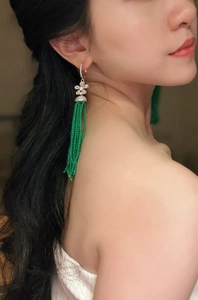Detail of vintage flower earrings with green beaded tassels and clear zircon stones