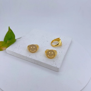 Macro-opname van gouden smiley ringen met zirkonia pavé op een witte stenen basis