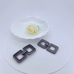 Detail of interlocking gunmetal square earrings with micro-paved cubic zirconia