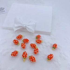 Vista macro de colgantes de fresa con perlas y aros dorados para la creación de joyería DIY