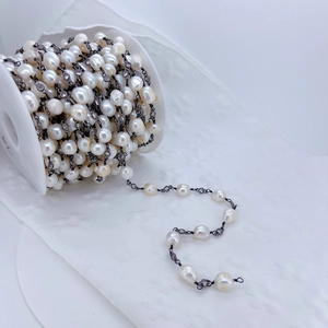 Detailed view of Baroque pearl chain with zircon accents on a reel for jewelry making