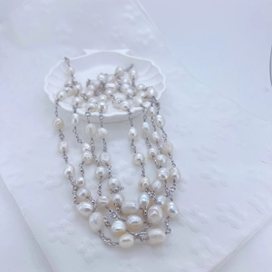 Macro detail of multi-layered baroque pearl necklace with sparkling zircon accents