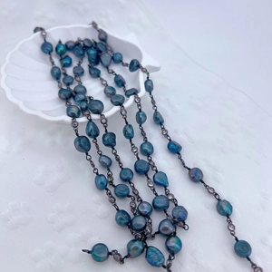 Baroque peacock pearl necklace with zircon accents on a white shell tray
