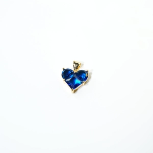 Détail d'un pendentif coeur en pierre bleue foncée avec sertissage à griffes doré